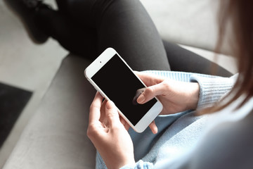 Woman using mobile phone indoors