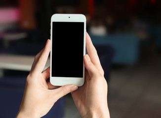 Woman using mobile phone on blurred background