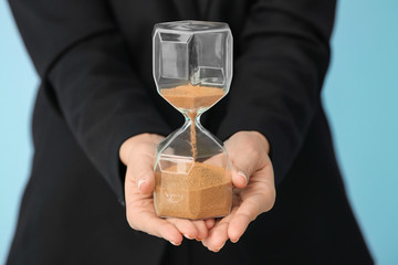 Woman holding hourglass, closeup. Time management concept