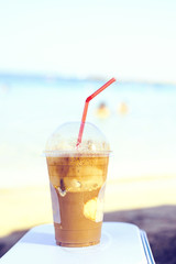 Daylight view to iced latte coffee drink near seashore