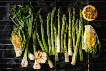 Grilled vegetables green asparagus, garlic, lemon, spring onion, salad on bbq grill rack over...