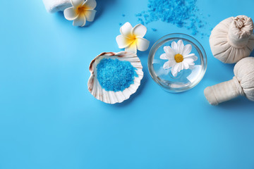Beautiful spa composition with sea salt and flowers on color background