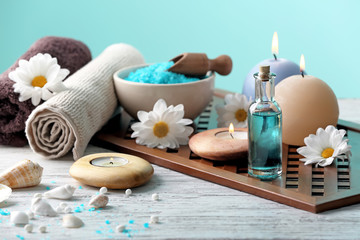 Beautiful composition with flowers, candles and spa accessories on wooden table