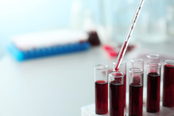 Dripping blood into test tubes, closeup