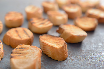 Tasty toasted bread on grey background