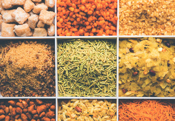 Indian Tea-time snacks like sev, chivda, farsan, mixture, boondi, bakarwadi etc served in white...