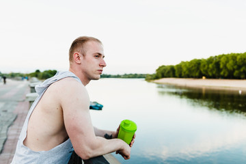 An athlete with a shaker after a hard training near the river.