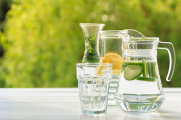 Three variants of fresh homemade lemonade with lemon, cucumber and mint. Lemonade in jugs and...
