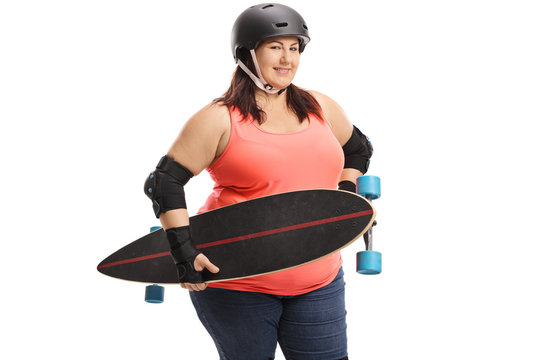 Overweight woman holding a longboard and wearing protective gear