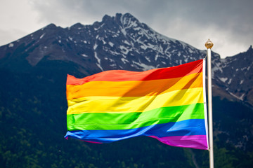 LGBTQ rainbow flag with snowy mountain background view
