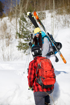 Picture of man from back and women with mountain skis