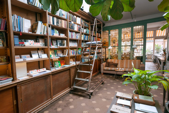 Bookstore with antique bookshelves, decoration, couch and table for coffee and lunch of readers