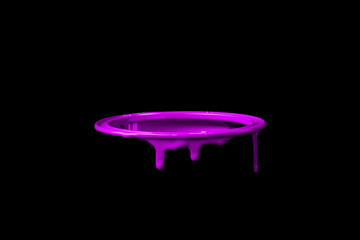 Pink paint leaking over the wall of empty metal bucket. Isolated over black background
