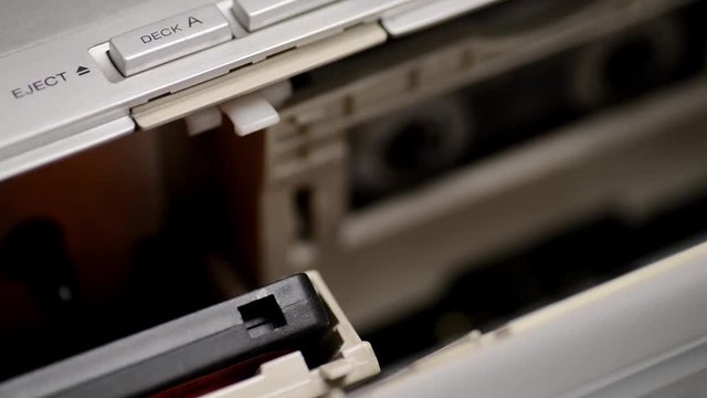 caricando una musicassetta nel datato lettore stereo 