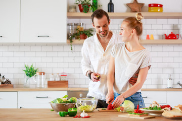 Photo of beautiful loving couple cooking vegetables in kitchen