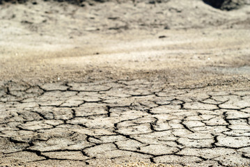 background - dried cracked saline soil, dry clay sprinkled with sand