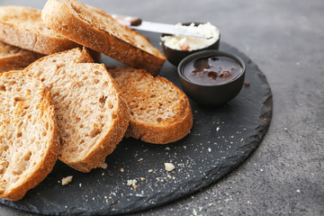 Toasted bread with jam and cream cheese on slate plate