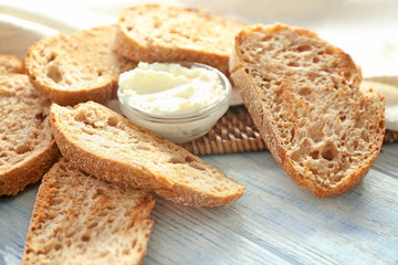 Toasted bread with cream cheese on wooden table