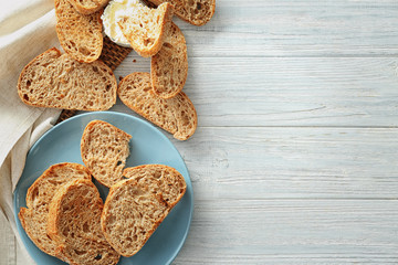 Flat lay composition with toasted bread on wooden background