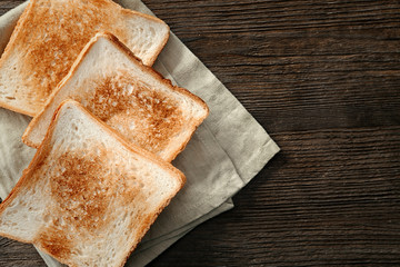 Toasted bread on wooden background, top view