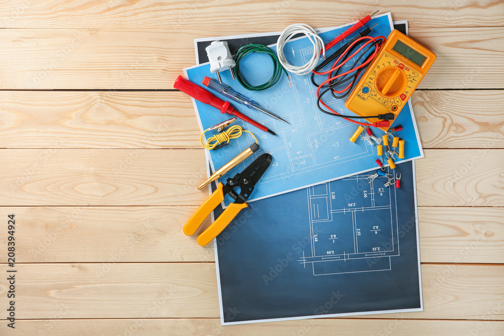 Wall mural Flat lay composition with electrical tools and house plan on wooden background