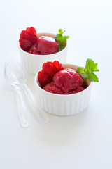 Fruit strawberry sorbet with mint in bowl on white wooden background.