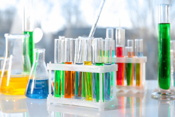 Chemical glassware with colorful samples on table