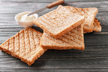 Toasted bread and cream cheese on wooden background