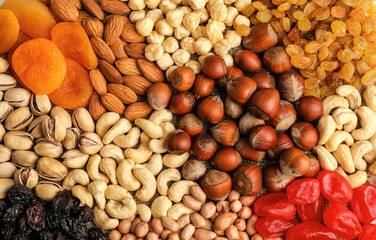 Different nuts, dried fruits and berries as background