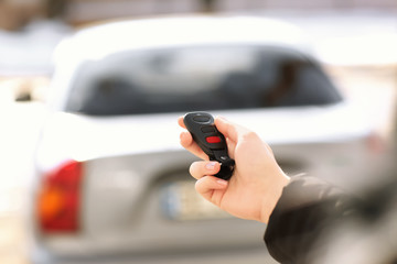 Young woman using car alarm outdoors
