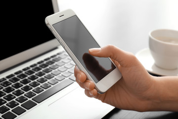 Young woman using smartphone at table