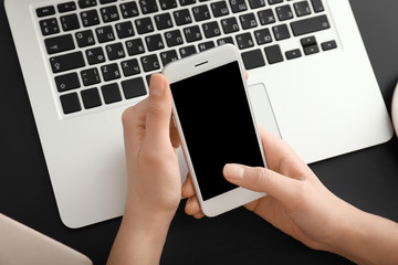 Young woman using smartphone at table