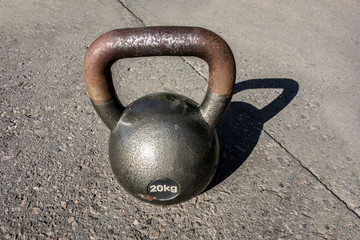 Fototapeta na wymiar Rusty old dumbbell for weightlifting weighing 20 kg