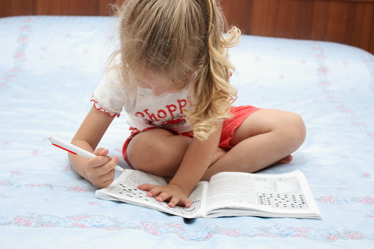 Bambina che fa le parole crociate