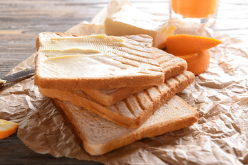 Delicious toasts with butter on table