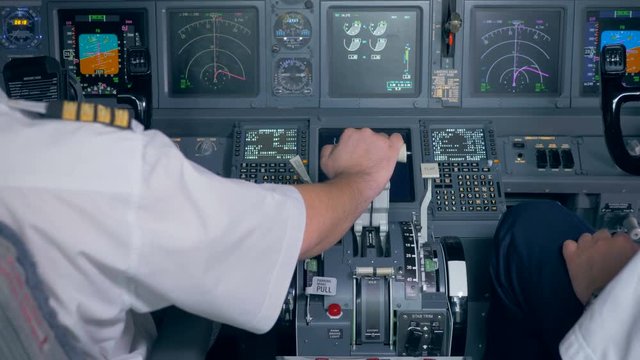 Pilot's hand is located on a throttle lever in an aircraft cockpit
