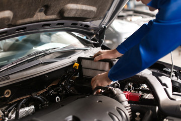 Obraz na płótnie Canvas Male mechanic examining car in service center