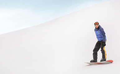 Male snowboarder on slope at winter resort