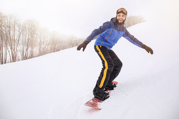 Male snowboarder on slope at winter resort