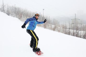 Fototapeta na wymiar Male snowboarder on slope at winter resort