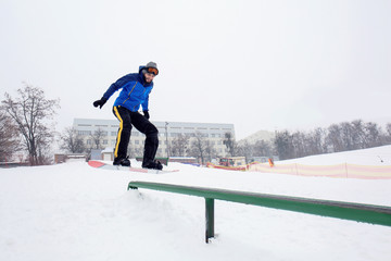 Male snowboarder doing trick at winter resort