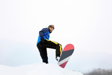 Male snowboarder on slope at winter resort