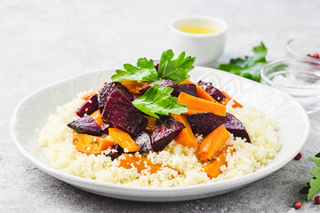 Couscous roasted root vegetables on concrete background. Selective focus, space for text.