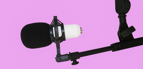 Microphone installed on a rack on a pink background