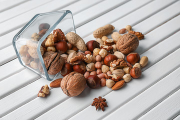 Bowl and different nuts on wooden table