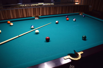 colored balls of the American pool and cue on the billiard table