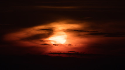 Sun at sunset surrounded by dark clouds