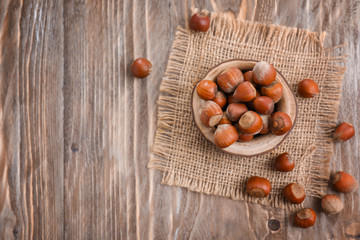 Bowl with hazelnuts on wooden table