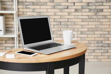 Stylish workplace with laptop on table