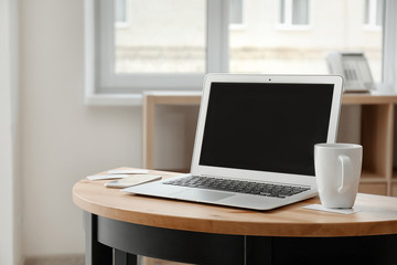 Stylish workplace with laptop on table